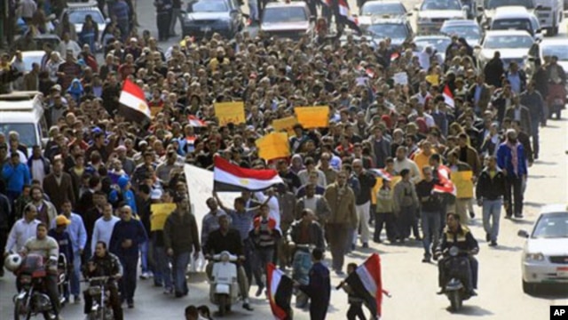 Anti-government protesters march through a street in Cairo, Egypt. Egypt's military threw its weight Friday behind President Hosni Mubarak's plan to stay in office through September elections, February 11, 2011.