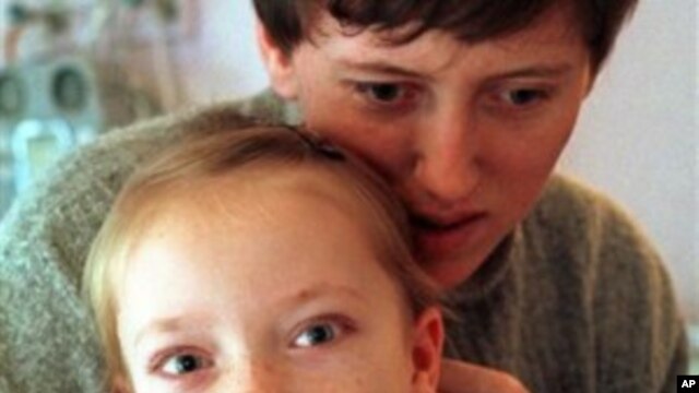Yulia Kostina, 9, from the southern Ukrainian Crimean Peninsula, is embraced by her mother at the intensive care unit of the Endocrinology Institute in Kiev, Ukraine, after undergoing cancer surgery (File Photo)