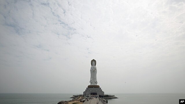 Tourists walk towards a 108-meter high Buddhist statue at Nanshan Cultural Center, about 60km (37 miles) west of Sanya, in south China's Hainan Island province. (file photo)