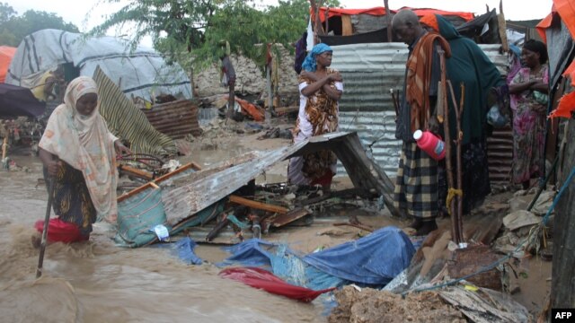 FILE - Members of a family stand next to their makeshift house that was swept at the internally displaced people (IDP) camp in Hodon district in Mogadishu, Somalia, May 30, 2015, following heavy rain that has pounded the parts of the country. United Nations predicts that up to 900,000 people could be hit by the strongest El Niño weather phenomenon in decades.