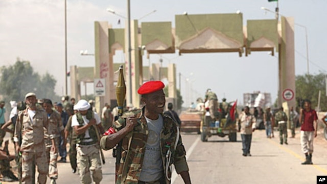 Anti-Gaddafi fighters stand guard after they took over El-Khamseen gate, the eastern gate of Sirte, Libya, September 24, 2011.