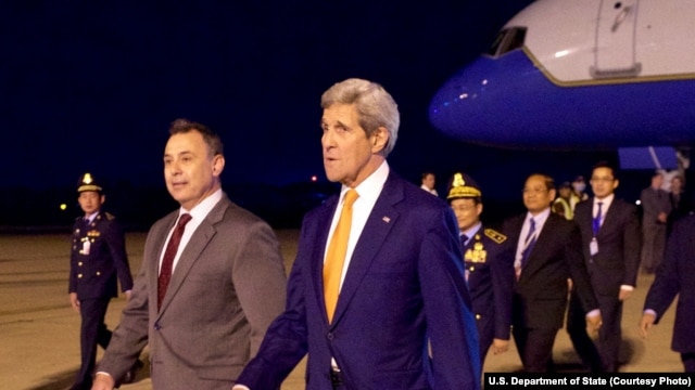 U.S. Ambassador to Cambodia William Heidt, center, escorts U.S. Secretary of State John Kerry, right, after he arrives at Phnom Pehn International Airport in Phnom Pehn, Cambodia, Jan. 25, 2016.