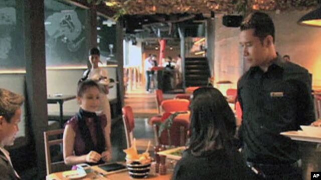 Diners enjoy a meal at the newly-opened Smoking Joe's Barbecue and Lounge, which serves genuine American barbecue, in Jakarta, Indonesia, May 2011