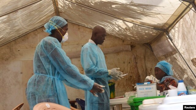 Các nhân viên y tế lấy máu xét nghiệm virus Ebola tại một căn lều khám bệnh ở Kenema, Sierra Leone. 