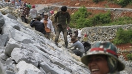 In this Oct. 6, 2012 photo, local workers adjust stones at another dam construction site by China National Heavy Machinery Corporation on the Tatay River in Koh Kong province, some 210 kilometers (130 miles) west of Phnom Penh, Cambodia.