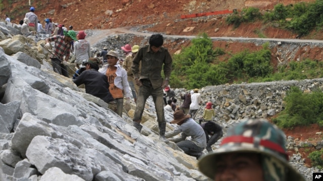 Local workers adjust stones at a dam construction site by China National Heavy Machinery Corporation on the Tatay River in Koh Kong province, some 210 kilometers (130 miles) west of Phnom Penh.