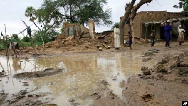 A picture released by Oxfam and taken on17 Aug 2010 shows people standing near homes destroyed by flooding near Zinder