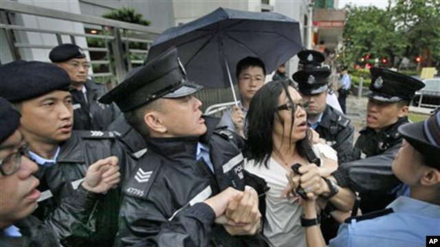 A protester scuffles with police officers who were trying to stop a fellow demonstrator from throwing a bag of tofu during a protest to support Chinese dissident Tan Zuoren at the Chinese government's liaison office in Hong Kong, 9 June 2010.