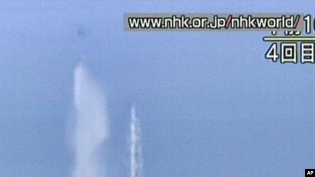This screengrab taken off Japanese national broadcaster NHK shows a Japanese military twin-rotor cargo helicopter dumping water onto reactor no. 3 at the stricken Fukushima nuclear power plant on March 17, 2011.