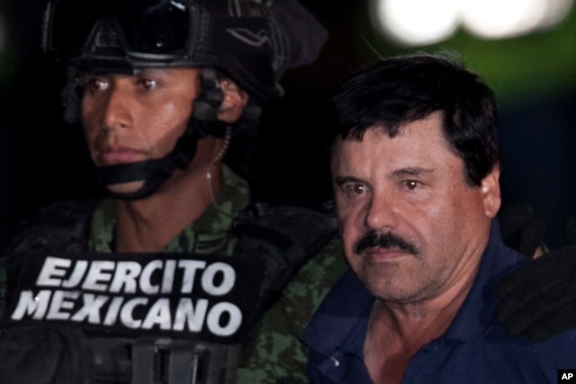 Mexican drug lord Joaquin "El Chapo" Guzman, right, is escorted by soldiers and marines to a waiting helicopter, at a federal hangar in Mexico City, Jan. 8, 2016.