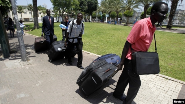 South Sudanese men carry luggage as they walk towards Tel Aviv's central bus station to board a bus to Ben Gurion airport, Israel, June 17, 2012. 
