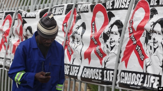 Một người đàn ông đi qua các biểu ngữ Ngày Thế giới phòng chống AIDS ở Johannesburg, Nam Phi, ngày 1/12/2014.