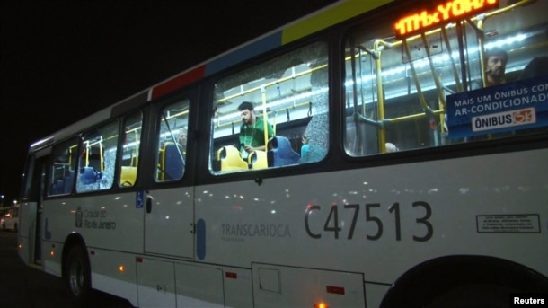 People are shown on an official media bus after its window was shattered while driving journalists to the Main Transport Mall from the Deodoro Stadium of the Rio 2016 Olympic Games in Rio de Janeiro, Aug. 9, 2016.