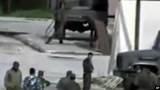 Image from amateur video made available by Shaam News Network Jan. 16, 2012, purports to show Syrian security forces in Hama, Syria.  AP CANNOT INDEPENDENTLY VERIFY THE CONTENT, DATE, LOCATION OR AUTHENTICITY OF THIS MATERIAL.