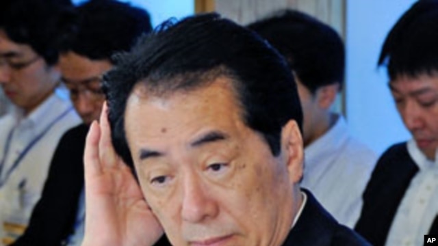 Japanese Prime Minister Naoto Kan gestures upon his arrival for a cabinet meeting on environment and energy at Kan's official residence in Tokyo, June 22, 2011