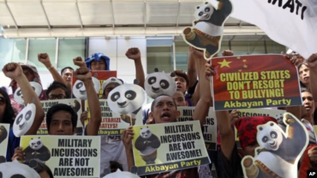 Protesters shout slogans during a rally outside the Chinese Consulate at financial district of Makati city, east of Manila, Philippines to protest alleged Chinese government's alleged military incursions into the disputed Spratly group of islands in the S