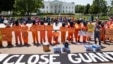 Activists wearing orange jumpsuits mark the 100th day of prisoners