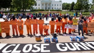 Activists wearing orange jumpsuits mark the 100th day of prisoners' hunger strike at Guantanamo Bay during a protest in front of the White House in Washington May 17, 2013. 