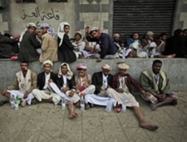 Yemeni anti-government protesters rest sitting on a sidewalk chewing Qat during clashes between the factions in Sana'a, March 13, 2011.
