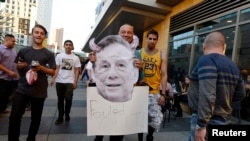 A Los Angeles Clippers fan holds a cut out picture of owner Donald Sterling as the fan arrives to attend the Clippers playoff game five against the Golden State Warriors at the Staples Center in Los Angeles, California, April 29, 2014.