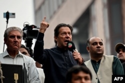 Mantan Perdana Menteri Pakistan Imran Khan (tengah) berbicara kepada para pendukungnya dalam pawai anti-pemerintah menuju ibu kota Islamabad, menuntut pemilihan awal, di Gujranwala, 1 November 2022. (Foto oleh Arif ALI / AFP)