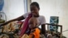 FILE - A mother sits with her malnourished baby at a hospital run by Doctors Without Borders in Jonglei state, South Sudan, on Dec. 28, 2021. A report released by United Nations agencies on Nov. 3, 2022, said up to 222 million people globally face acute hunger.