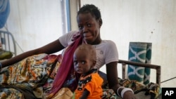 FILE - A mother sits with her malnourished baby at a hospital run by Doctors Without Borders in Jonglei state, South Sudan, on Dec. 28, 2021. A report released by United Nations agencies on Nov. 3, 2022, said up to 222 million people globally face acute hunger.