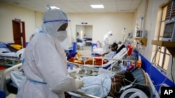 FILE — Medical workers attend to coronavirus patients in the intensive care unit of an isolation and treatment center in Machakos, south of the capital Nairobi, in Kenya, Nov. 3, 2020.