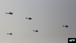 FILE - Myanmar Air Force helicopters take part in a display by the country's military government to mark Myanmar's 77th Armed Forces Day, in Naypyidaw, March 27, 2022.