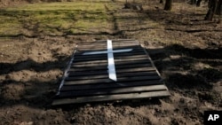 Natalia Vlasenko buried her husband, Pavlo Vlasenko, in her yard under part of a fence, seen in this April 4, 2022, photo, in Bucha, Ukraine. Russian soldiers beat Pavlo Vlasenko to death and then set his body on fire.