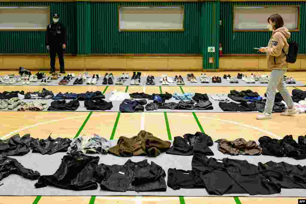 Seorang jurnalis berjalan di antara barang-barang pribadi yang diambil oleh polisi dari lokasi kerumunan maut acara Halloween yang menewaskan sedikitnya 156 orang di distrik Itaewon, di sebuah gimnasium untuk dikumpulkan oleh kerabat korban, di Seoul, Korea Selatan.