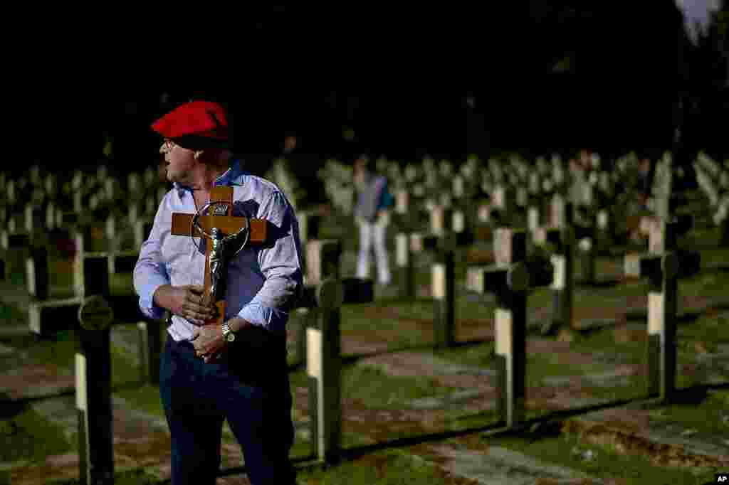 Una persona que viste la tradicional boina roja de los Requetes, una milicia rebelde que luchó contra el gobierno republicano, sostiene un crucifijo en memoria de los rebeldes asesinados en la guerra civil española (1936-1939) durante el Día de Todos los Santos, una festividad católica para reflexionar sobre los santos y familiares difuntos, en el cementerio estatal de Pamplona, ​​al norte de España.