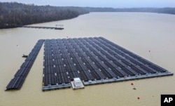 Panel surya dipasang di pembangkit listrik fotovoltaik terapung di sebuah danau di Haltern, Jerman, Jumat, 1 April 2022.(AP/Martin Meissner)