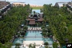 Para tamu berkumpul di sekitar area kolam renang Hotel Apurva Kempinski yang bersiap dijadikan tempat utama KTT para pemimpin G20, di Bali, Rabu, 25 Mei 2022. (Foto: AP)