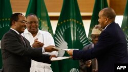 Redwan Hussien Rameto (L), Representative of the Ethiopian government, and Getachew Reda (R), Representative of the Tigray People's Liberation Front (TPLF), exchange documents after signing a peace agreement between the two parties, Nov 2, 2022.