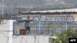 An inmate stands on the roof of the Litoral Penitentiary in Guayaquil, Ecuador, on Nov. 2, 2022. Police and soldiers on Wednesday patrolled the terror-stricken streets of two Ecuadorian cities after a spate of attacks blamed on organized crime groups waging a deadly drug war.