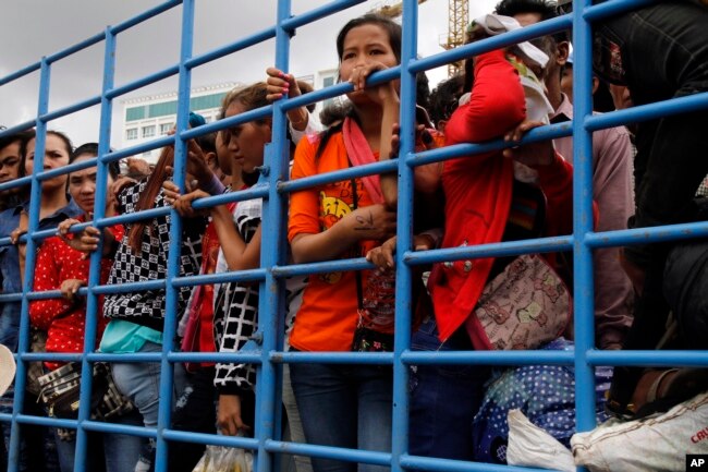 រូបឯកសារ៖ ពលករចំណាកស្រុកកម្ពុជាឈរនៅក្នុងឡានដែលបានដឹកពួកគេចេញពីប្រទេសថៃមកដល់ច្រកព្រំដែនខ្មែរថៃនៅក្រុងប៉ោយប៉ែត កាលពីថ្ងៃទី១៧ ខែមិថុនា ឆ្នាំ២០១៤។