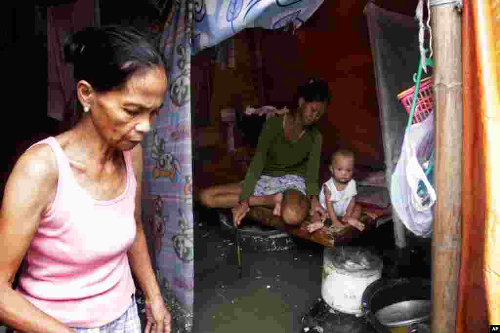 A family stays inside their shelter in a flooded evacuation center, Aug. 2, 2012 in Navotas City, Philippines.