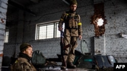 Ukrainian servicemen stand near their armoured vehicles at the frontline town of Bakhmut, in eastern Ukraine's Donetsk region on October 31, 2022, in response to Russia's invasion of Ukraine.