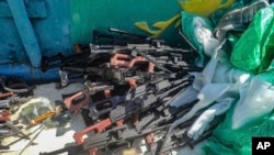 FILE - This Feb. 12, 2021 photo released by the U.S. Navy shows a large cache of weapons, including Kalashnikov-style rifles and rocket-propelled grenade launchers, it seized from a smuggler's ship off the coast of Somalia. 