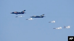 FILE - Myanmar Air Force fighter jets drop bombs during exercises Feb. 2, 2018, in Myanmar's Ayeyarwaddy delta region. In a report released Nov. 3, 2022, Amnesty International is urging suppliers of aviation fuel to Myanmar's military government to suspen