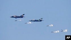 FILE - Myanmar Air Force fighter jets drop bombs during exercises Feb. 2, 2018, in Myanmar's Ayeyarwaddy delta region. In a report released Nov. 3, 2022, Amnesty International is urging suppliers of aviation fuel to Myanmar's military government to suspend such shipments.