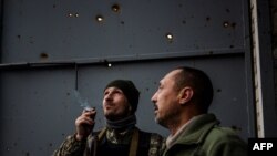 Ukrainian servicemen look up to the sky after hearing the sound of a drone at their position at the frontline town of Bakhmut, in eastern Ukraine's Donetsk region on October 31, 2022.