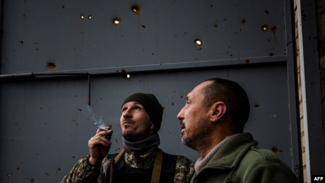 Ukrainian servicemen look up to the sky after hearing the sound of a drone at their position at the frontline town of Bakhmut, in eastern Ukraine's Donetsk region on October 31, 2022.
