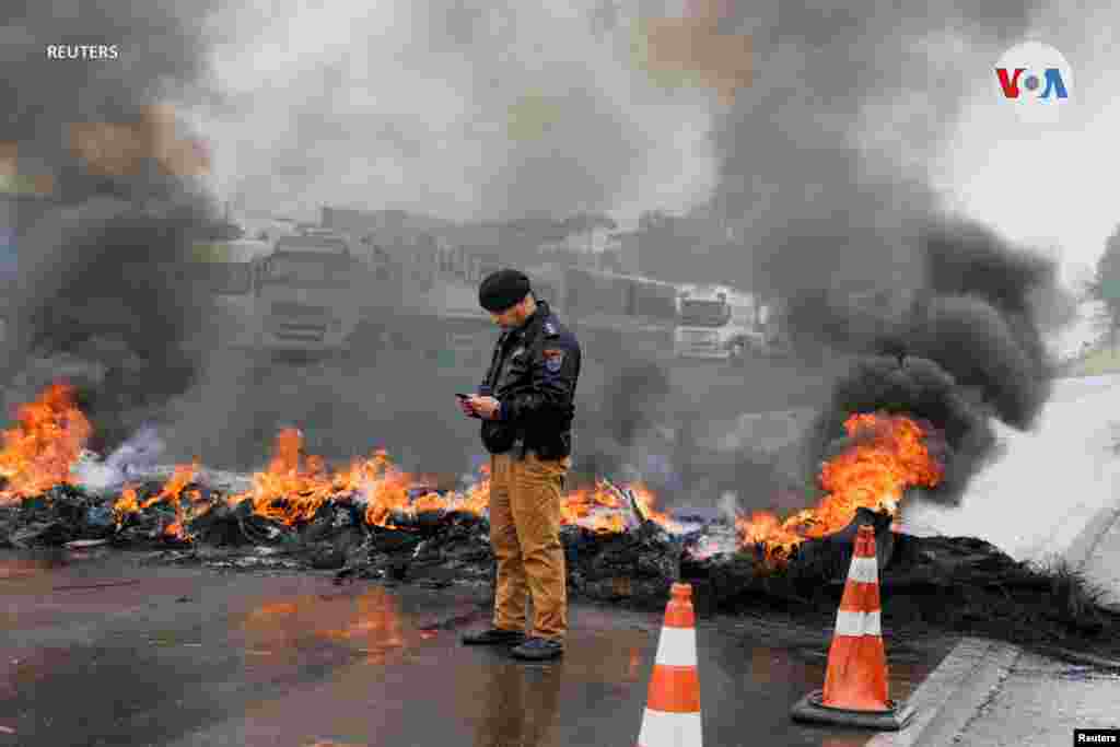 Un miembro de la policía militar del estado de Paraná consulta un teléfono mientras partidarios del presidente Bolsonaro bloquean una carretera durante una protesta, en Curitiba, en el estado de Paraná, Brasil, el 1 de noviembre de 2022.&nbsp;