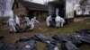Волонтери завантажують тіла мирних жителів, убитих у Бучі, у вантажівку, щоб відвезти їх до моргу для розслідування, Україна, 12 квітня 2022 року.