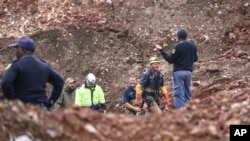 FILE: South African police investigate at the scene where more than 20 bodies, suspected of being illegal miners, were found near an active mine in Krugersdorp, South Africa, on Thurs., Nov. 3, 2022.