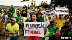 People attend a protest about Brazil's President Jair Bolsonaro's defeat in the presidential runoff election, in Anapolis, Goias state, Brazil, Nov. 2, 2022. Their signs read: 'Federal intervention.'