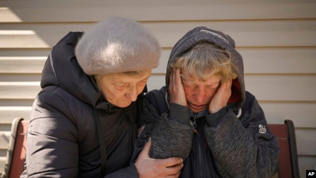Një fqinje ngushëllon Natalia Vlasenkon, të cilës forcat ruse i vranë burrin dhe nipin (Bucha, 4 prill 2022)
