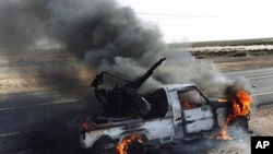 A pro-Moammar Gadhafi anti-aircraft machine gun is burned by Libyan rebels during a battle, in the town of Brega, east of Libya, March 2, 2011